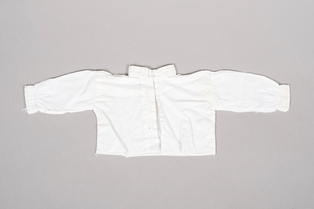 Hvit "bunadsskjorte" i bomull med kinakrage og hullbroderi langs kantene.