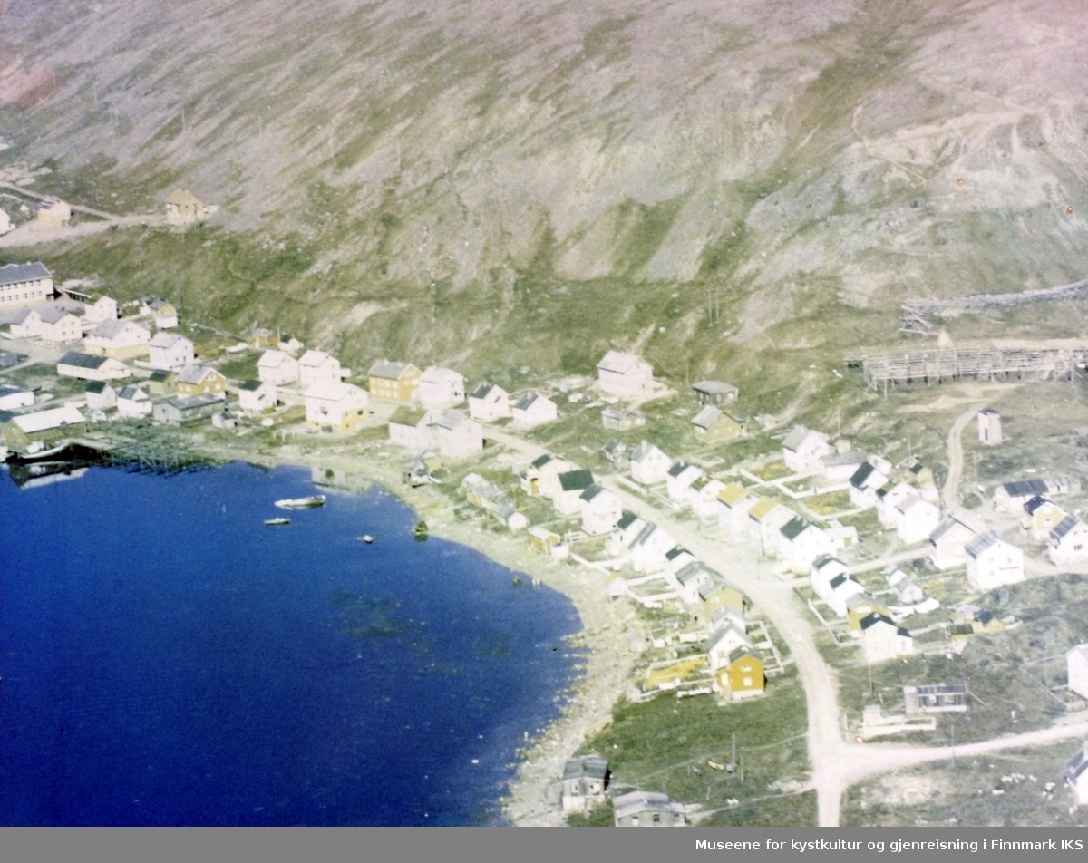 Flyfoto av deler av Nordvågen. Helt til venstre skolen, til høyre fiskehjeller. Slutten av 1960-tallet.