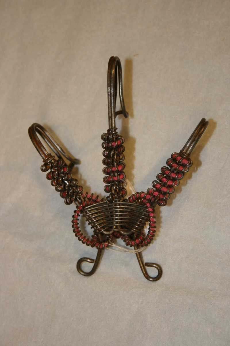 Tredelt krok, laga av ståltråd, Pynta med smal spiral fylt med rosa tråd.