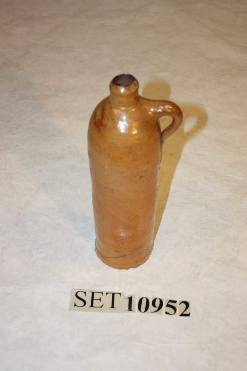 Sylinderforma keramikkrukke med smal hals og hank.