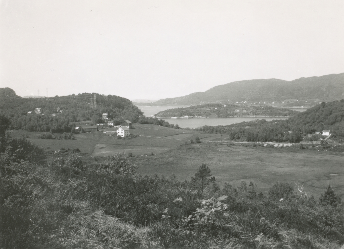 Oversiktsbilde av Lerstad, sett mot nord- vest. I bakgrunnen er Ellingsøyfjorden med øya Svinøy.