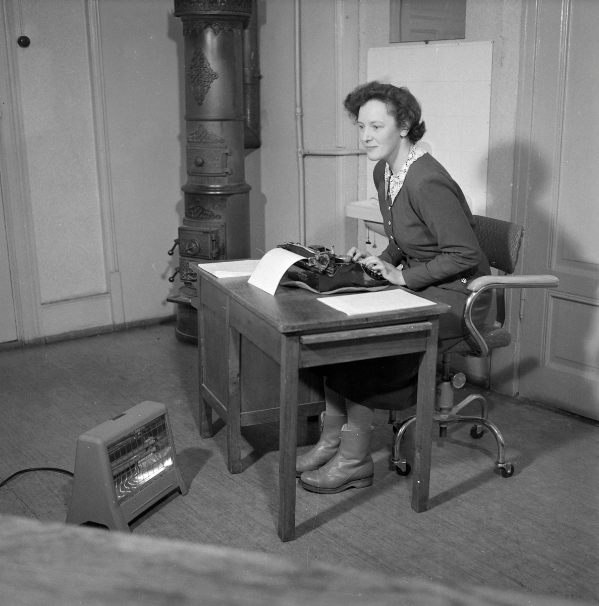 Kvinne på et kontor med koksovn og stråleovn