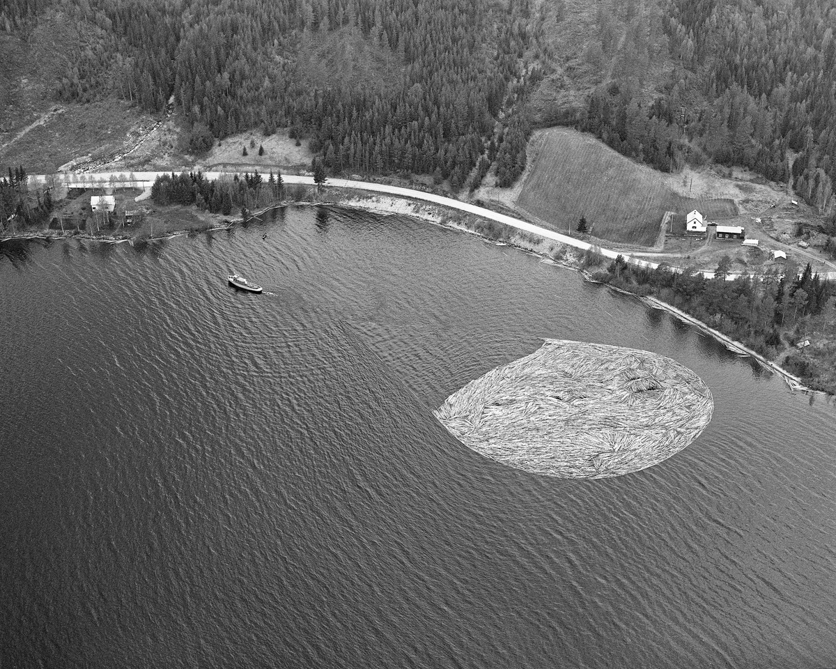 Flyfotografi, tatt over Fiskvikstøa i Ytre Rendalen, på Storsjøens vestside i 1981.  Vi ser hvordan riksveg 30 (her også kalt «Gamle kongeveg») slynget seg langs strandlinja. På vannspeilet ser vi en tømmerbom som ble slept sørover av tømmerslepebåten «Storsjø».  Det tok vanligvis drøyt 30 timer å trekke en slik ringbom fra området ved Åsheim i nordenden av innsjøen til utløpet i elva Søndre Rena, om lag 36 kilometer lengre sør.  Med de store tømmermengdene som ble fløtet i 1950- og 60-åra ble det gjerne omkring 30 turer, og sesongen varte om lag to måneder.  Da dette fotografiet ble tatt, i 1981, kunne 10-12 ringbommer romme det tømmeret som skulle fløtes ut av Rendalen.  Virksomheten ble avviklet etter 1984-sesongen.