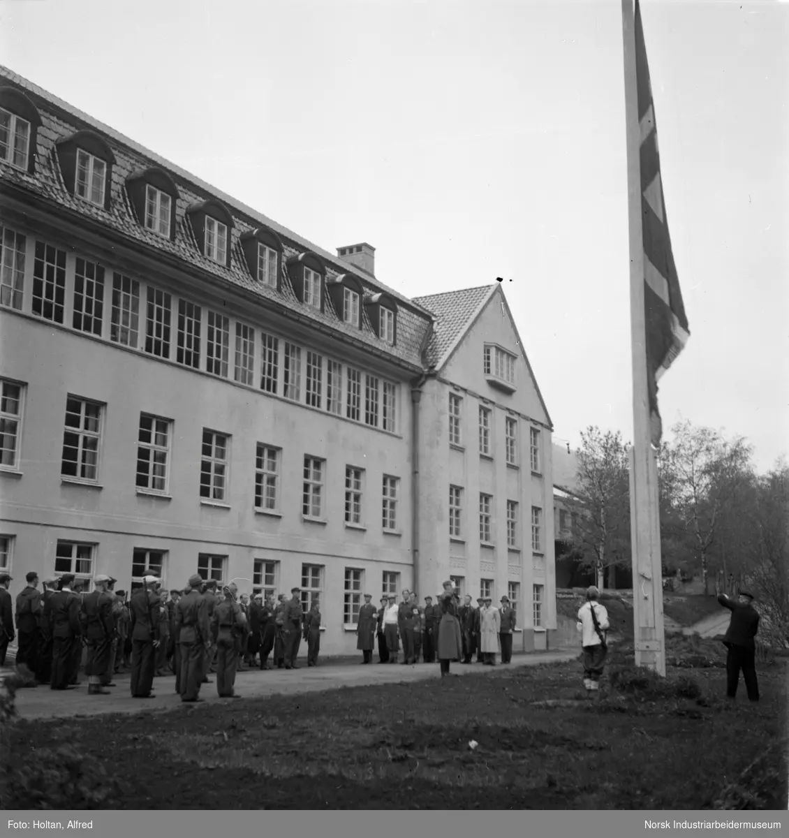 Det norske flagget heiset på nytt utenfor kontorbygget til Norsk Hydro i Rjukan, under frigjøringsdagene mai 1945.