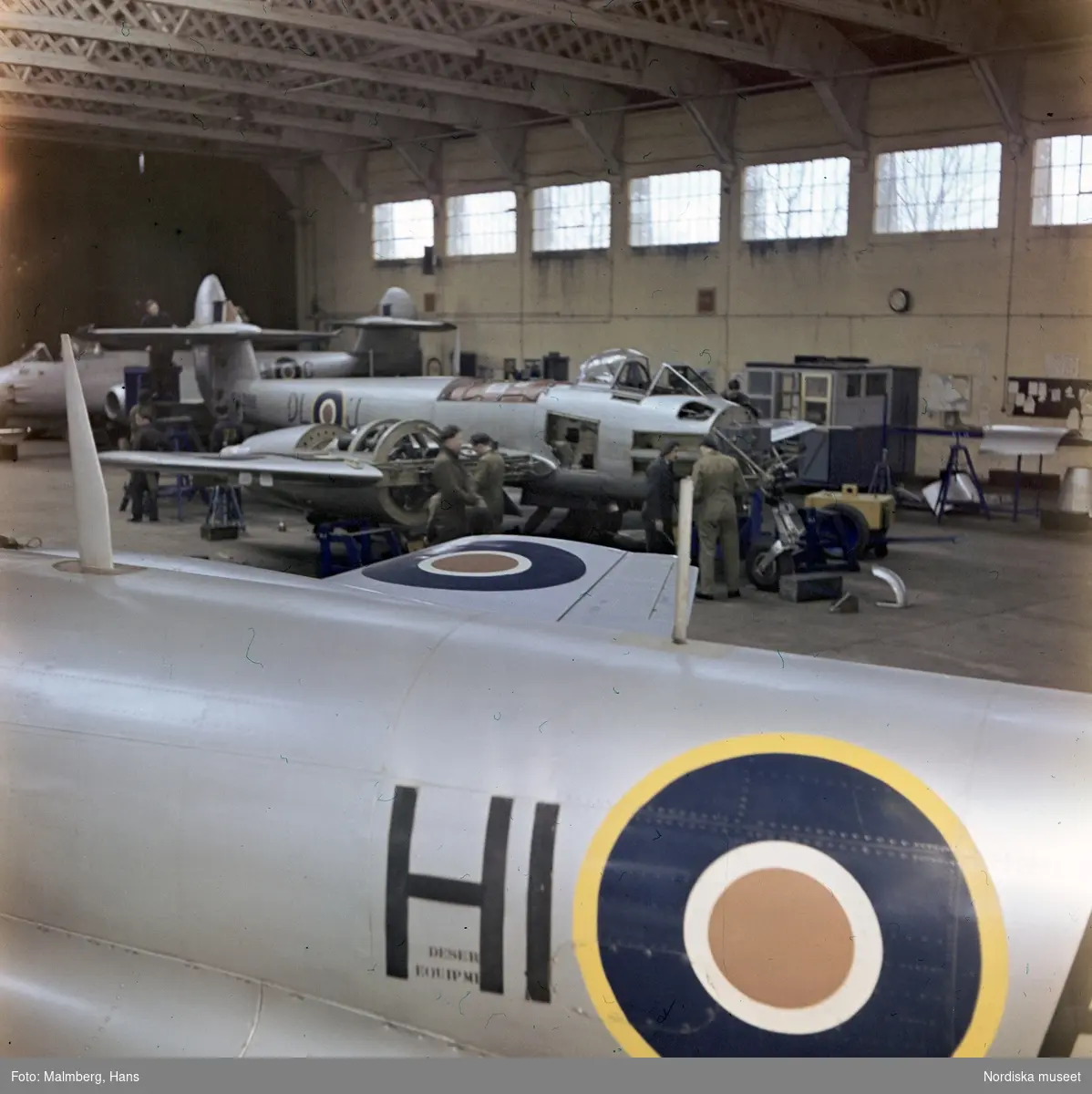 Brittiska flygvapnet, Royal Air Force (RAF). Mekaniker arbetar med jaktplan av typen Gloster Meteor i en hangar. Troligen flygbasen Duxford i Cambridgeshire, England.