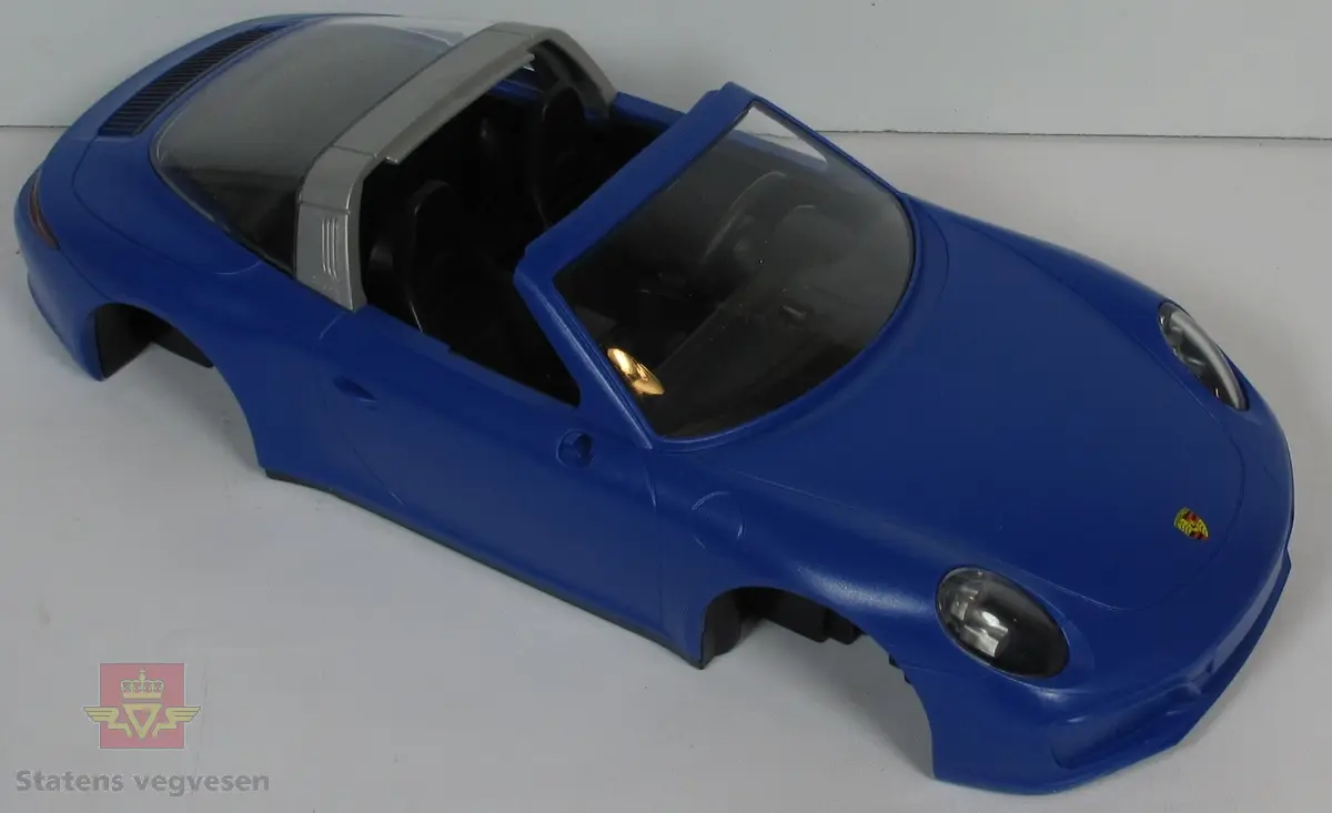 Miniatyr, lekebil i papp. Fargen er hovedsaklig blå, med bilde av bilen. Bilen har hovedsakelig fargen blå overalt. Antatt skala 1:14