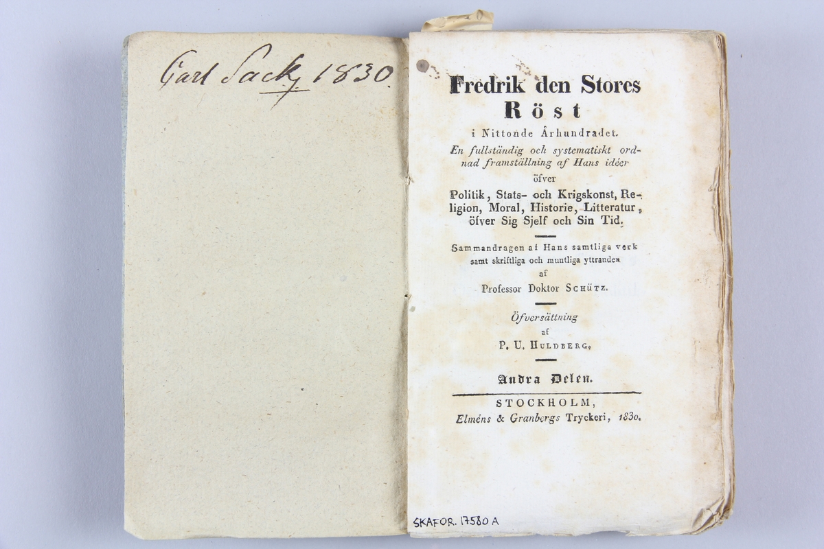 Bok, pappband, "Fredrik den Stores röst i nittonde århundradet", del 1, skriven av Schütz, tryckt 1830 i Stockholm
Pärm av blågrått papper, skuret snitt. På ryggen etikett med samlingsnummer.