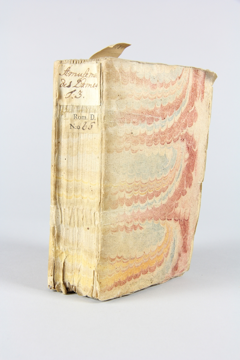 Bok, häftad "Amusemens des dames, ou receuil d´histoires galantes", del 3, tryckt 1741 i Haag.
Pärm av marmorerat papper, oskuret snitt. På ryggen etikett med titel och samlingsnummer.