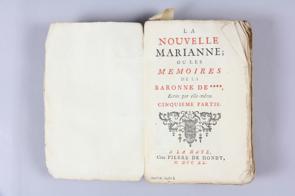 Bok, häftad, "La nouvelle Marianne ou les mémoires de la baronne de ****", del 5,6,7, tryckt i Haag 1740.
Pärm av marmorerat papper, oskurna snitt. På ryggen klistrade pappersetiketter med volymens namn och samlingsnummer. Ryggen blekt.