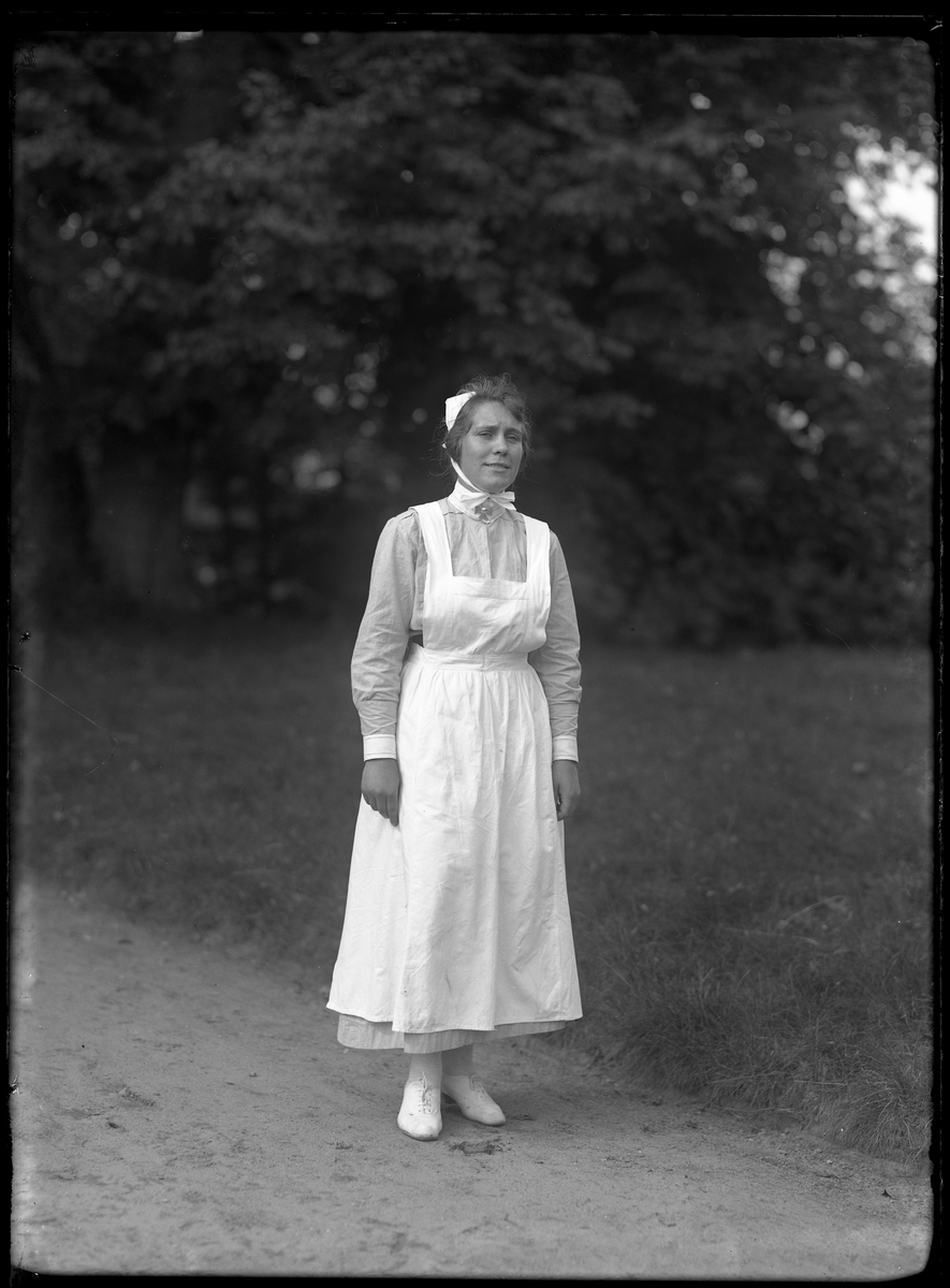 Porträtt av en sköterska klädd i uniform.