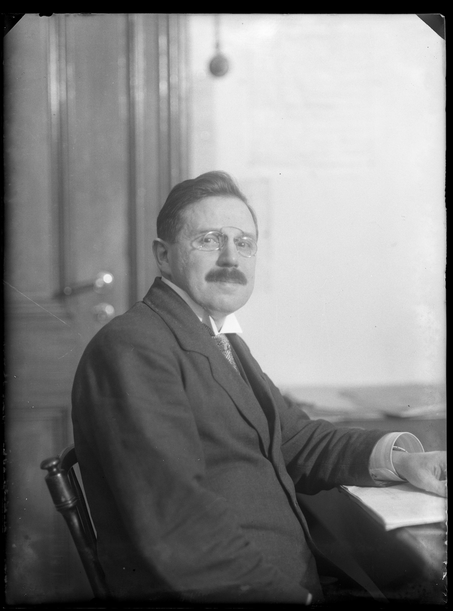 Herr Petersén (eller Petterssén) fotograferad sittandes vid ett skrivbord.