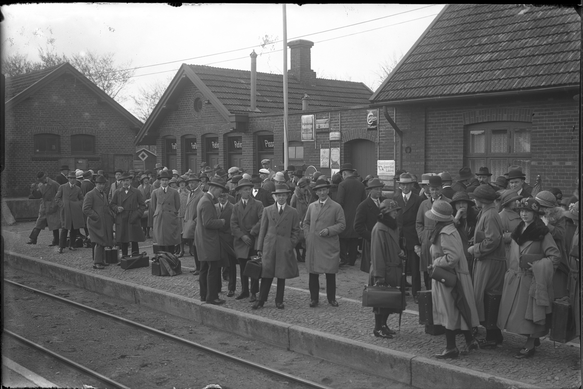 Tågresenärer på perrongen på Hörby station. I fotografens egna anteckningar står: Danmarksresan, Hörby station