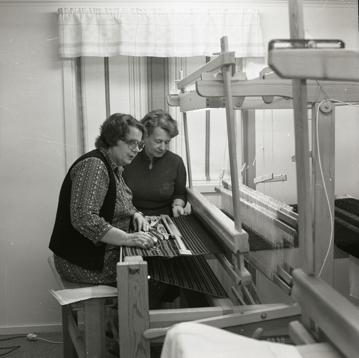 Adéle Mickelsson och en annan kvinna arbetar vid en vävstol ,1982.