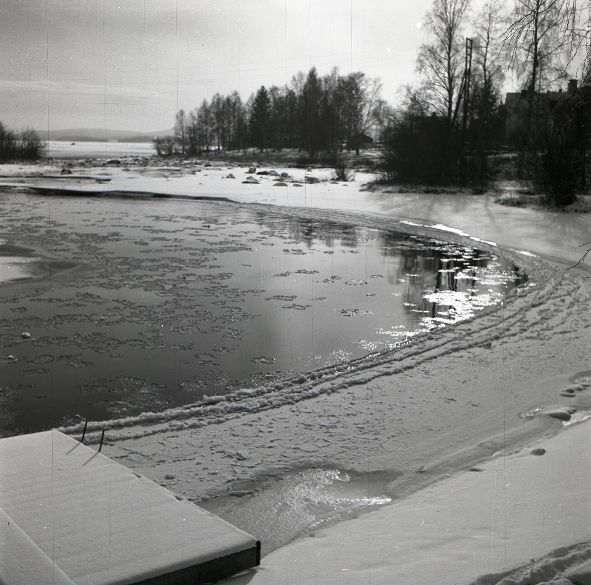 Isfläckar på Ljusnan intill en snötäckt strand, våren 1949.