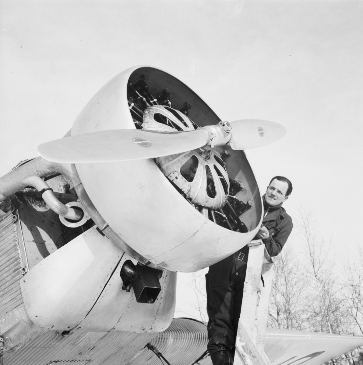 Motorarbete på flygplan Junkers F-13 vid F 19, Svenska frivilligkåren i Finland. Mekaniker Sture Krook står på en stege vid motorn.