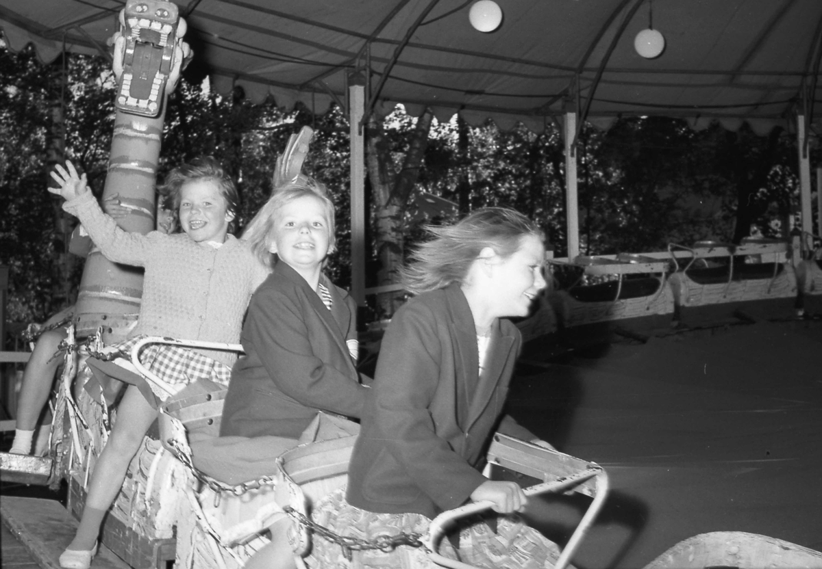 Barn på karusell , Gjøvik Gård 1961.  Søstrene Simonsen fra venstre Marit (Marte), Bodil (Bobbo) og Siri Gunn.