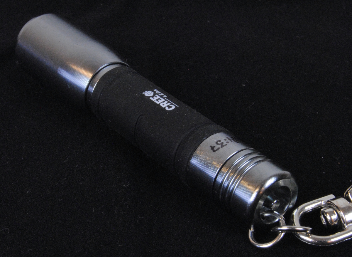 En liten LED ficklampa gjord av aluminium och med ett grepp av gummi. Ficklampan drivs av ett AAA batteri. Den hänger på en nyckelknippa.