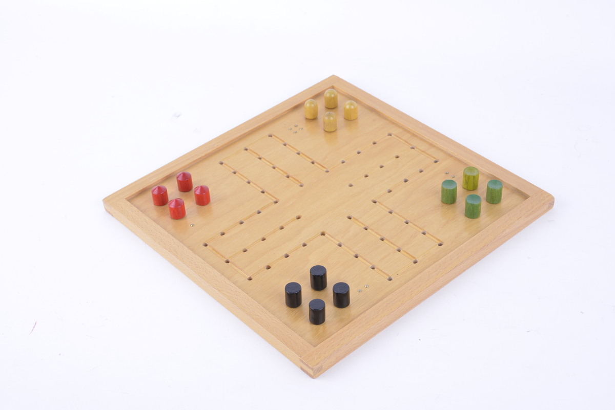 Kvadratisk brett i lyst, lakkert tre. Punktskrift i hvert hjørne. Brettet har hull som brikkene kan plasseres i. 16 spillbrikker. Fire gule, fire grønne, fire svarte og fire røde. Hver farge er ulikt utformet.