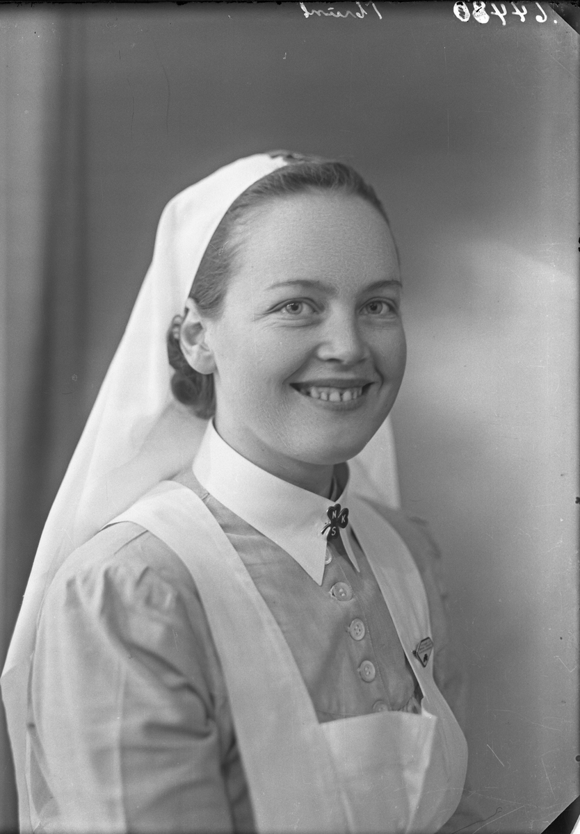 Portrett. Ung kvinne i sykesøsteruniform. Bestilt av Søster Anny Sund