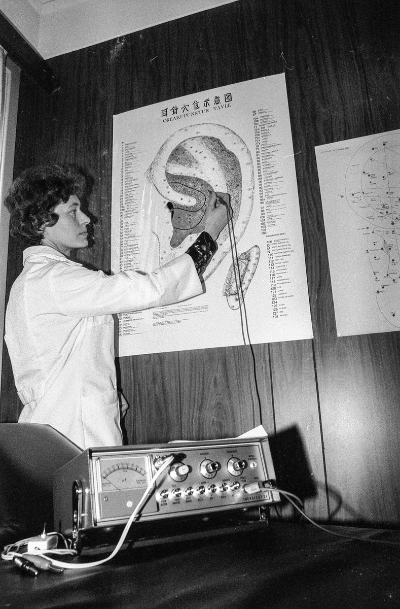 Homeopat Eva Langfeldt i Ski viser plansjer av Øret, kroppen, føtter og fotblad. Peker på punktene.