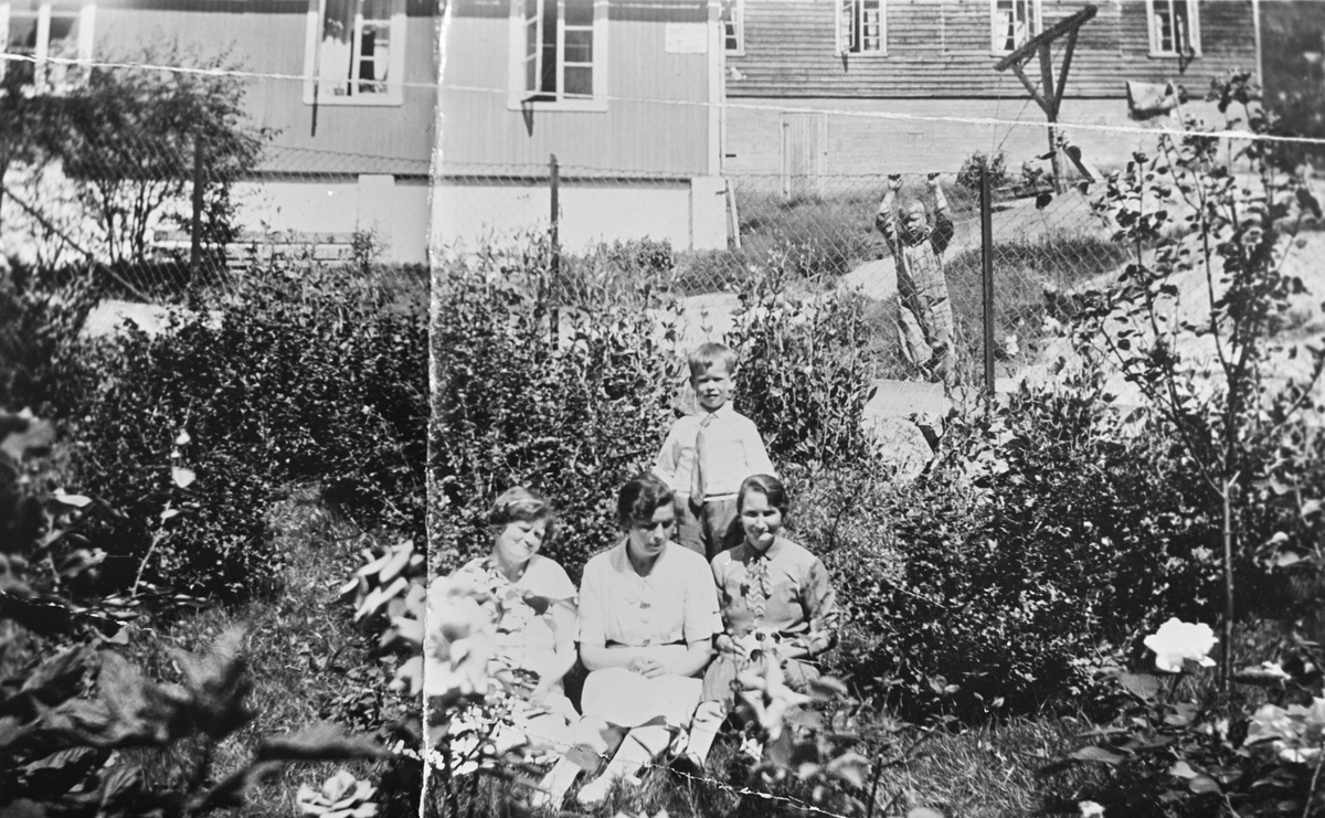 Kvinner og barn i hagen ved brakkebyen i Tyssedal