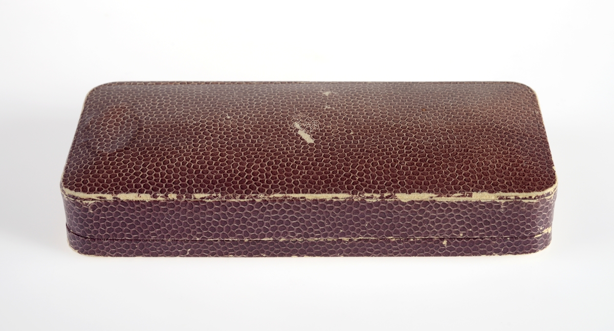 Rektangulær gaveeske i papp utenpå med et dyrisk mønster i brune nyanser. Inni er det satengvevd silke som er fòret.