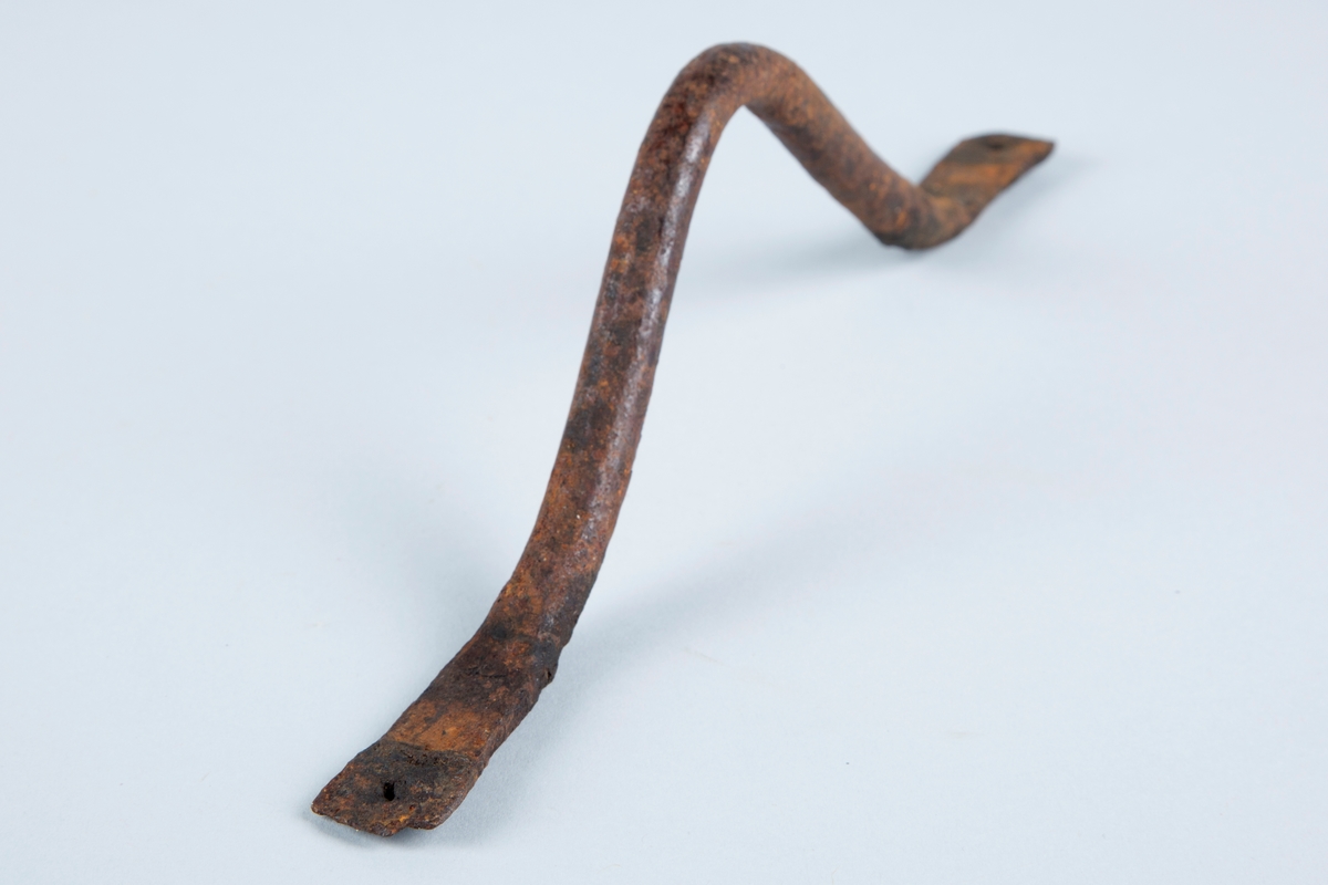 Håndtak laget av jern.
Formet som en bue, har hull for feste av f.eks skruer i begge ender