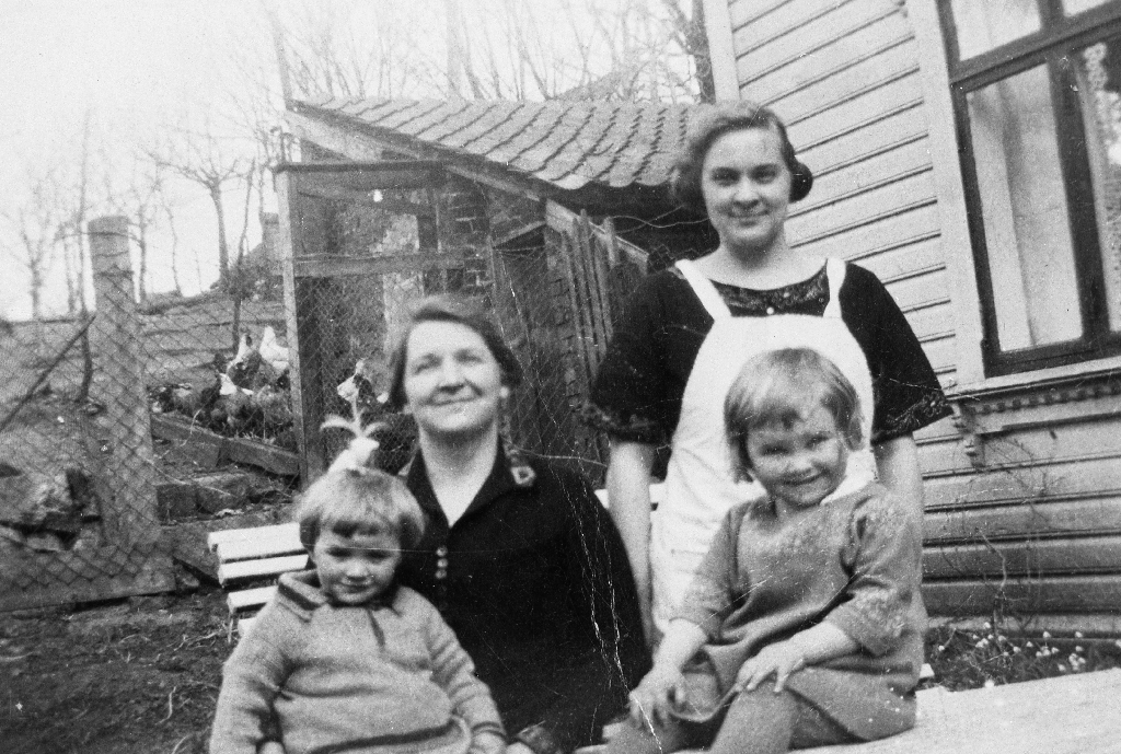 Lina Thilo med døtrene Sonja og Aud. Kvinna i kvitt forkle er "tante Elfrida". I bakgrunnen ser vi høner i hønsegården.