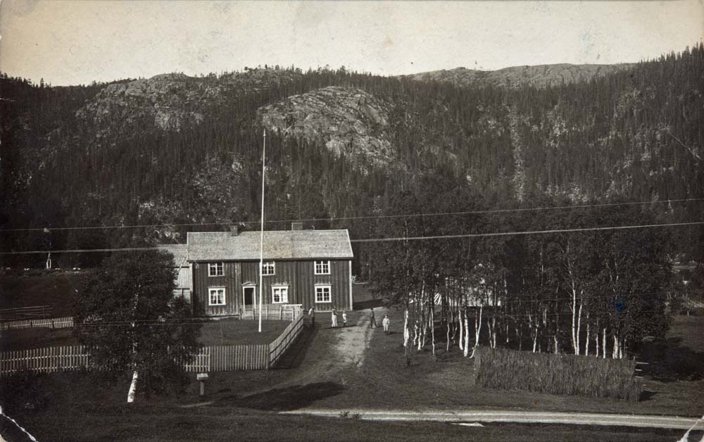 Postkort fra Nordstad i Bjørnådalen. G.nr.94, b.nr.4. Flaggstang. Flere personer og barn står på tunet.