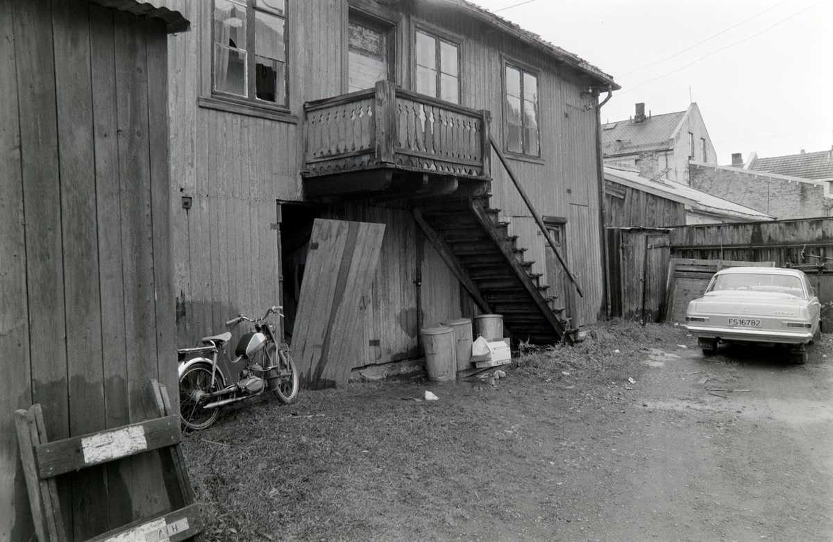 Østregate 12, Hamar. Bakgård, moped, søppeldunker, personbil,