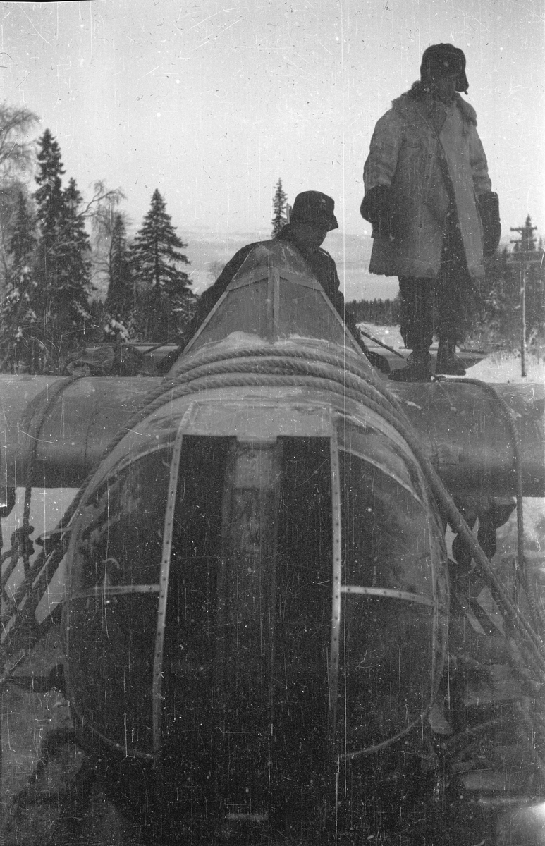 Transport av nedskjutet sovjetiskt flygplan SB-2 vid Svenska frivilligkåren i Finland, F 19. Närbild av flygplanets nos. Två militärer står på flygplanskroppen.