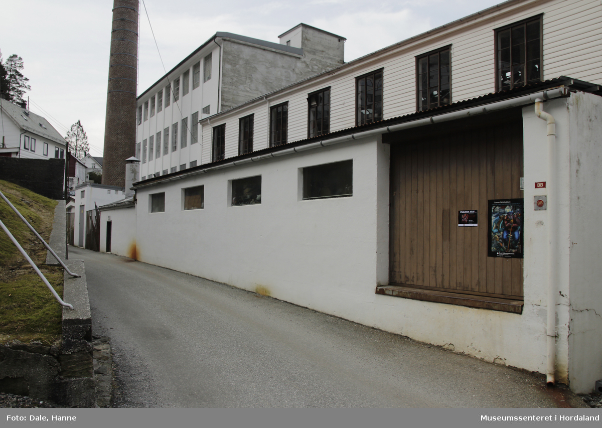 Del av produksjonslokala til Salhus Tricotagefabrik (1859-1989) bygd i 1863/1938. Brukt som produksjonslokale då fabrikken var i drift. Første etasje var ullblandingsrom med plys, andre etasje var brukt som lager.