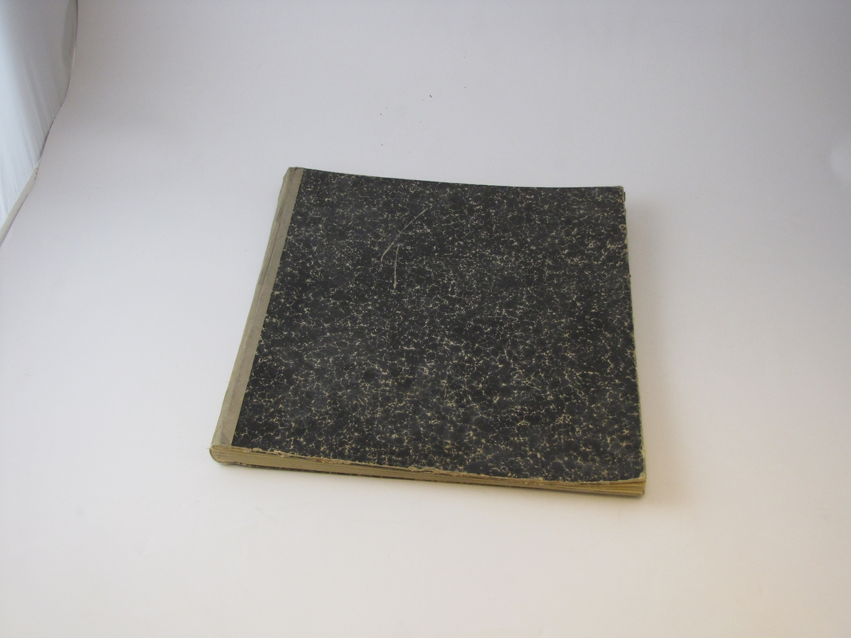 Bok med svart papiromslag og beige  tekstilrygg, det er mye slitasje på papiret. Boken inneholder regnskap