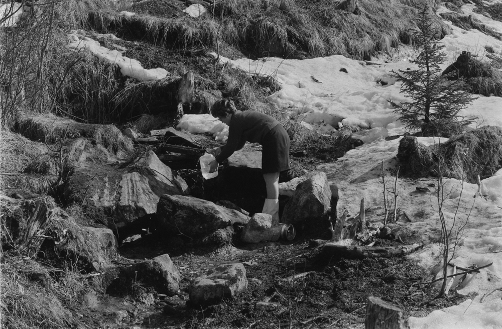 Vannhenting i Bjørnådalen, vannkilda sommeren 1969.
Dame som fyller vann på plastdunk.