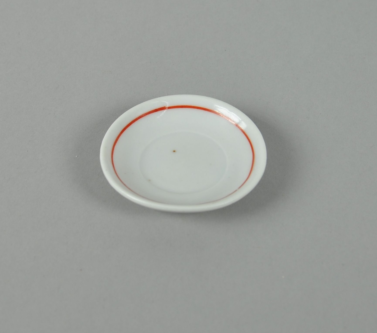 Skål av glassert keramikk. Hvit farge, med dekorativ ring i rødt.