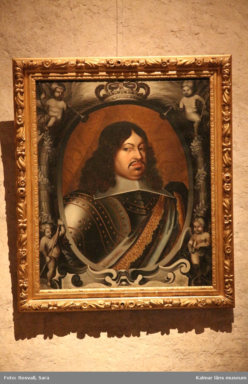Porträtt, bröstbild av Karl X Gustav i rustning. Vit, stärkt krage, över vänstra axeln ett draperi eller värjgehäng. Oval målad inramning med putti och lagerkransar. Över ovalen en krona, nedan början till textkartusch.