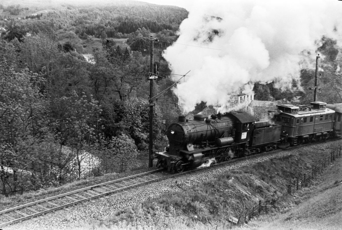Damplokomotiv type 33a nr. 300 med persontog retning Voss, tog 618, i Midttunbakken. Elektrisk lokomotiv type El 9 nr. 2063 medfulgte toget.