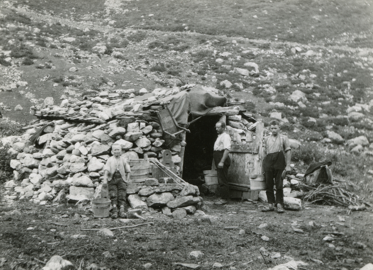 En familie ved ei bygning av stein på en støl under Susten Pass, Uri, Sveits.