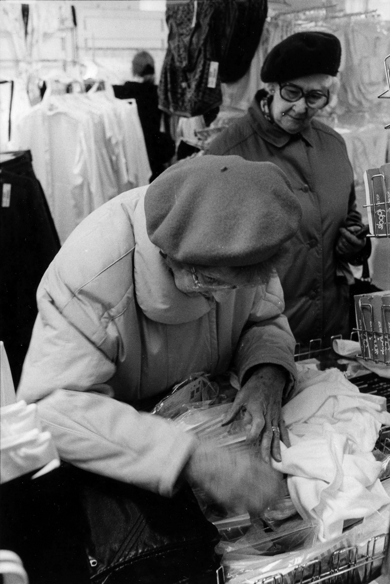 Två damer tittar på underkläder på damavdelningen inne på Lindex, Kungsgatan 32, kvarter Pärlan 7. I november 1990 flyttade butiken tillsammans med Gulins (senare Adelsten) in i Epas gamla varuhus i kvarter Storken 12.