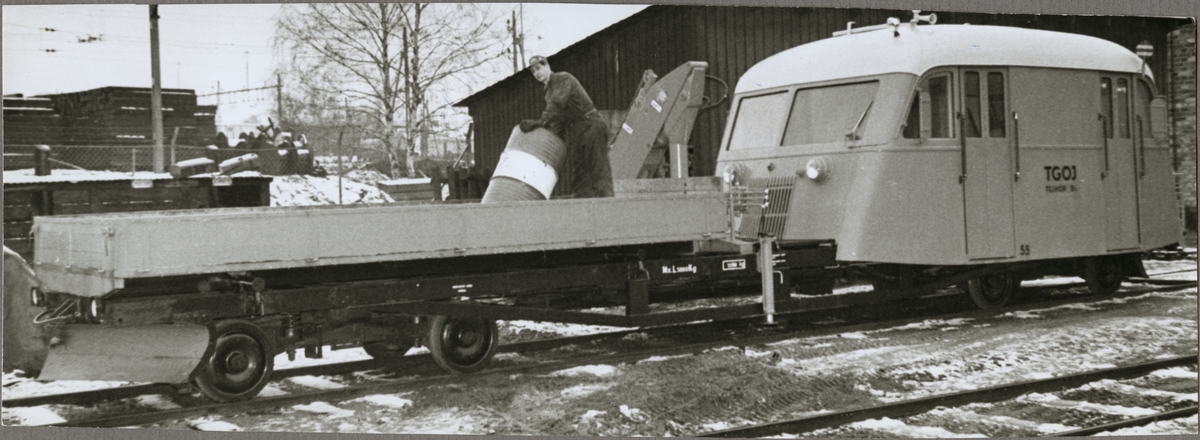 Ombyggd motorvagn med kran samt personal och gods på flak.