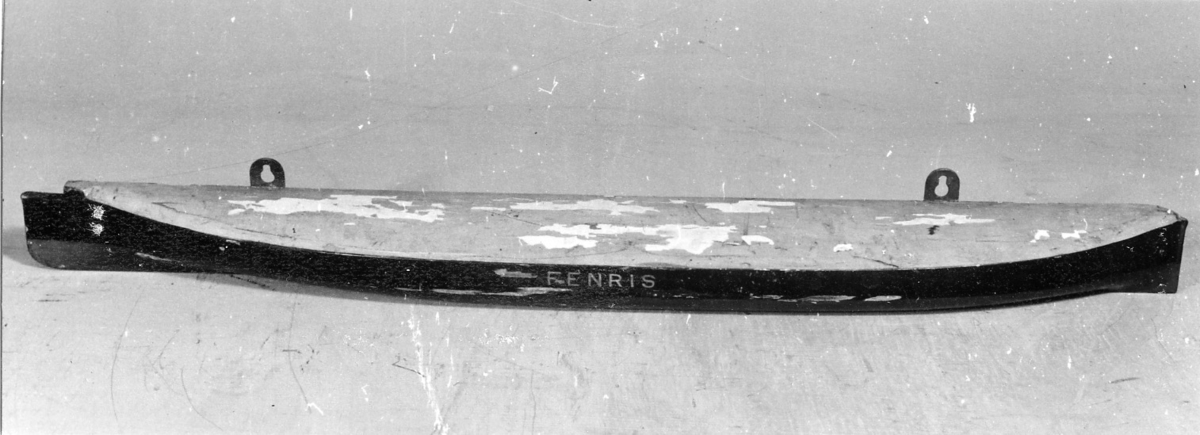 Halvmodell av bepansrade kanonbåten Monitor (3:e kl pansarbåten) Fenris byggd 1872. Byggd i block med två maljor för upphängning.
Svartmålad över vattenlinjen. Däcket gulmålat. Undervattenskroppen bronserad. Märkt mitt på sidan: "Fenris".