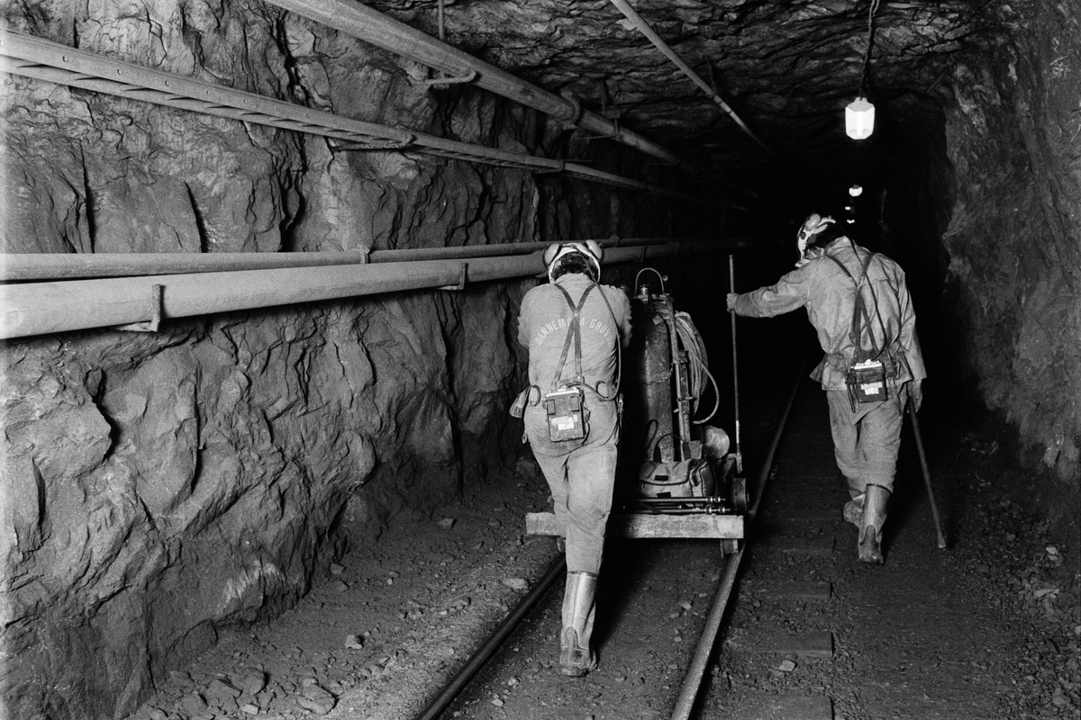 Gruvbyggarna Björn Karberg och Tomasz Stoltz transporterar en tralla på järnvägsspåret. De ska laga räls. 350-metersnivån, gruvan under jord, Dannemora Gruvor AB, Dannemora, Uppland oktober 1991