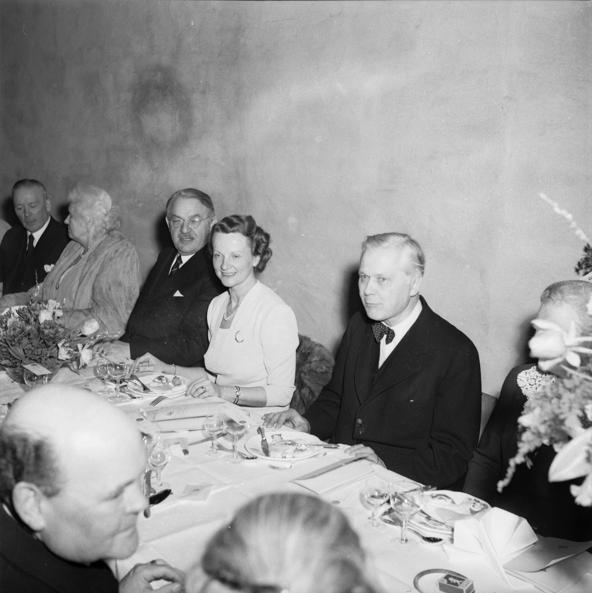 Män och kvinnor vid dukat bord, 75-årsjubileum, Upsala Ångqvarns AB, Uppsala 1949
