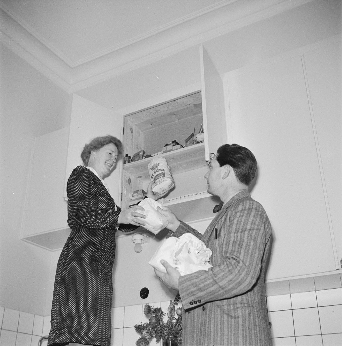 En man och kvinna i ett kök, inför Östgöta nations 300-årsjubileum, Uppsala 1946