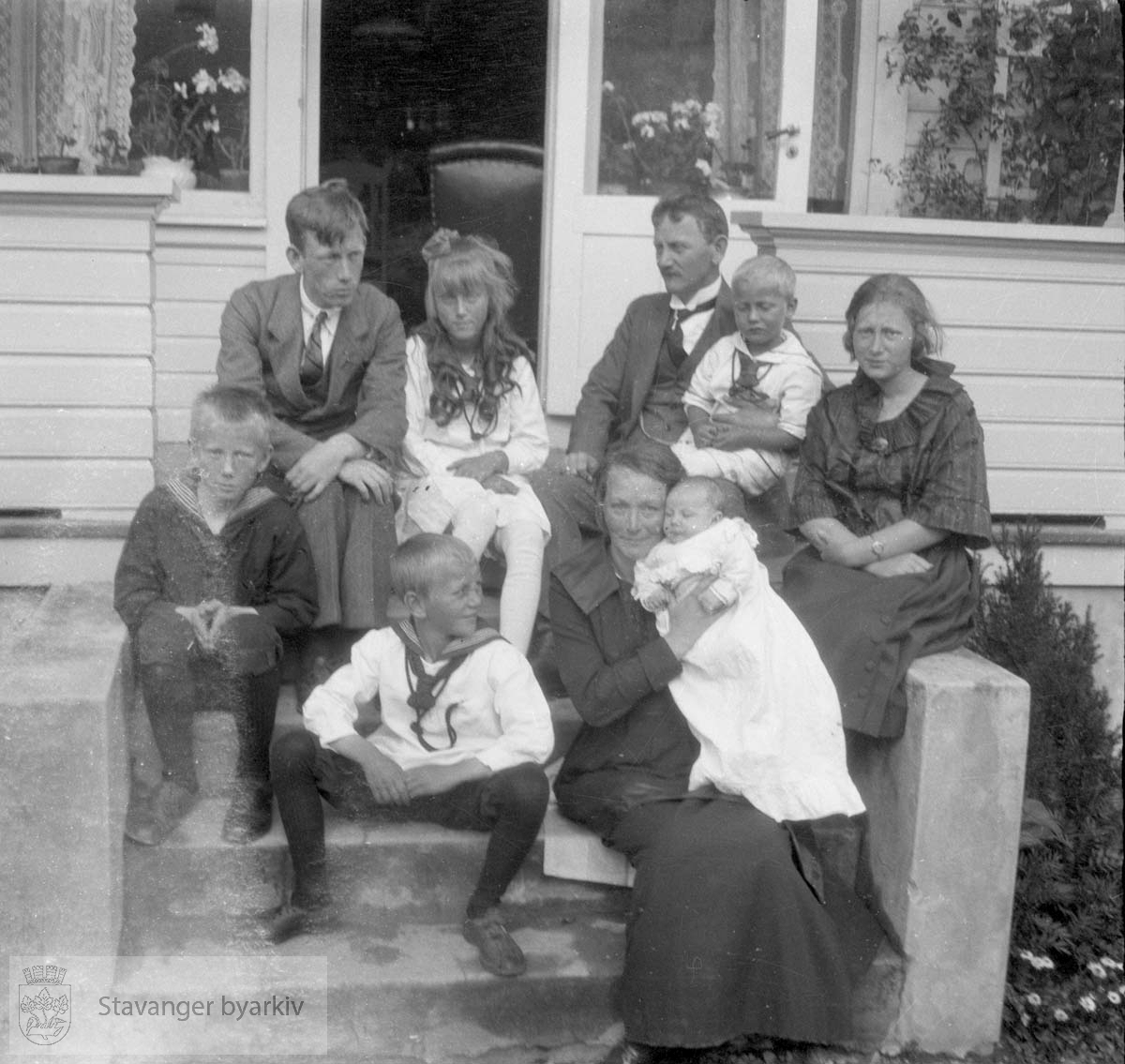 Familie på trapp foran hus