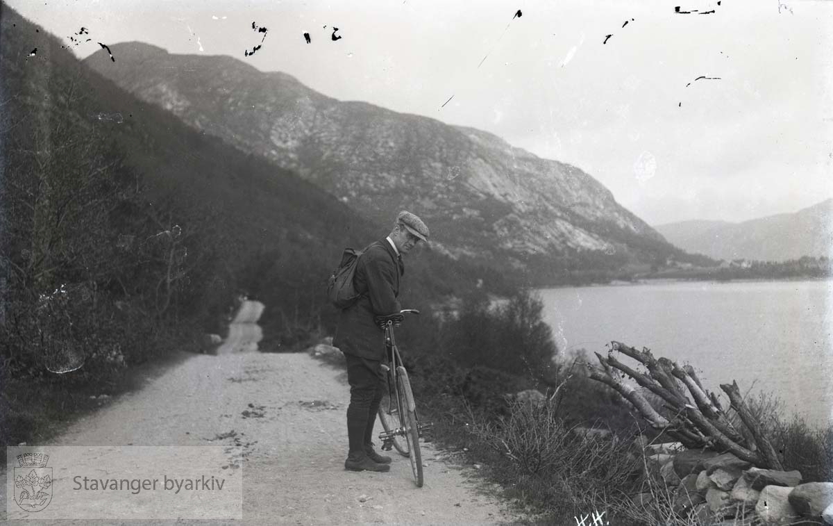 Mann med sykkel på turvei langs vann eller fjord