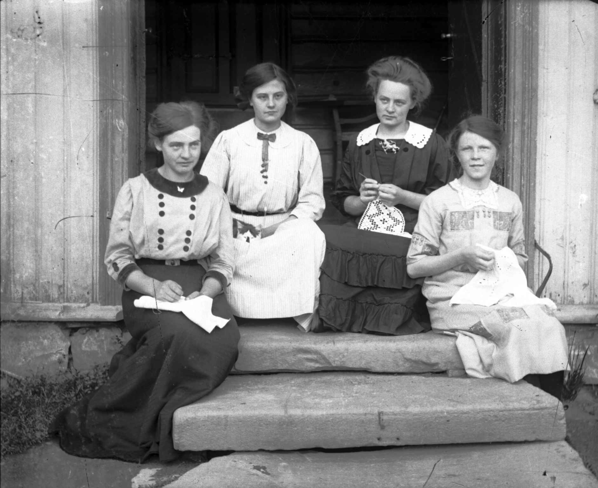 Fire unge kvinner på en trapp, en med en katt, de andre med hardangersøm. To av de skal være Agnes, til venstre og Kari Jørstad, nr3 fra venstre.