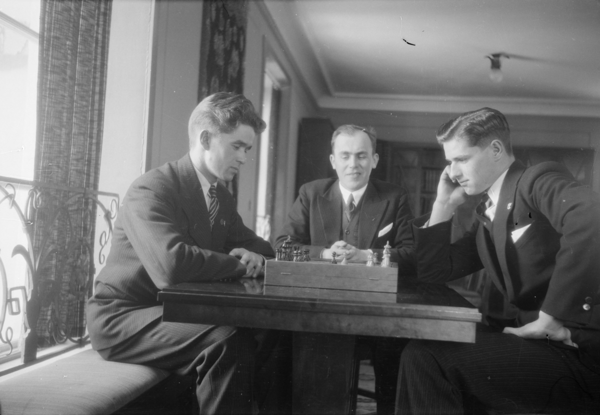 Tre menn rundt et sjakkbrett
