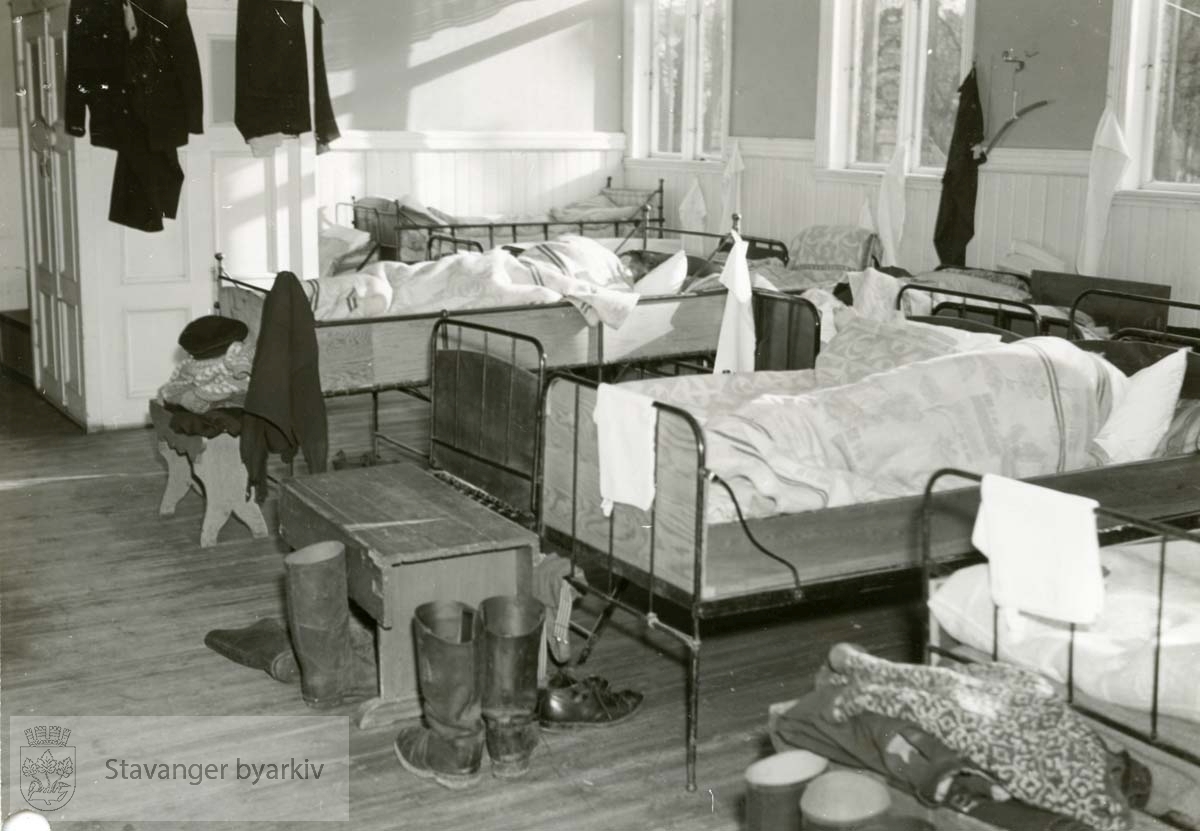 Brannmenn hviler. Arbeidstøy og sivile klær. Sovesalen i "gamla vaktå".