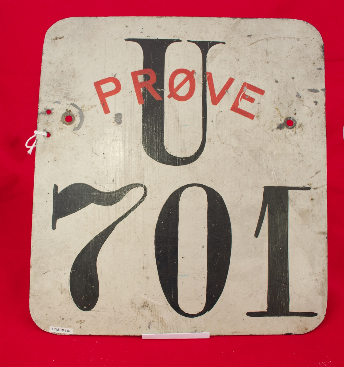 Stående rektangulært bilskilt i hvitt med nummer U 701 i sort og ordet "Prøve" med rød skrift.